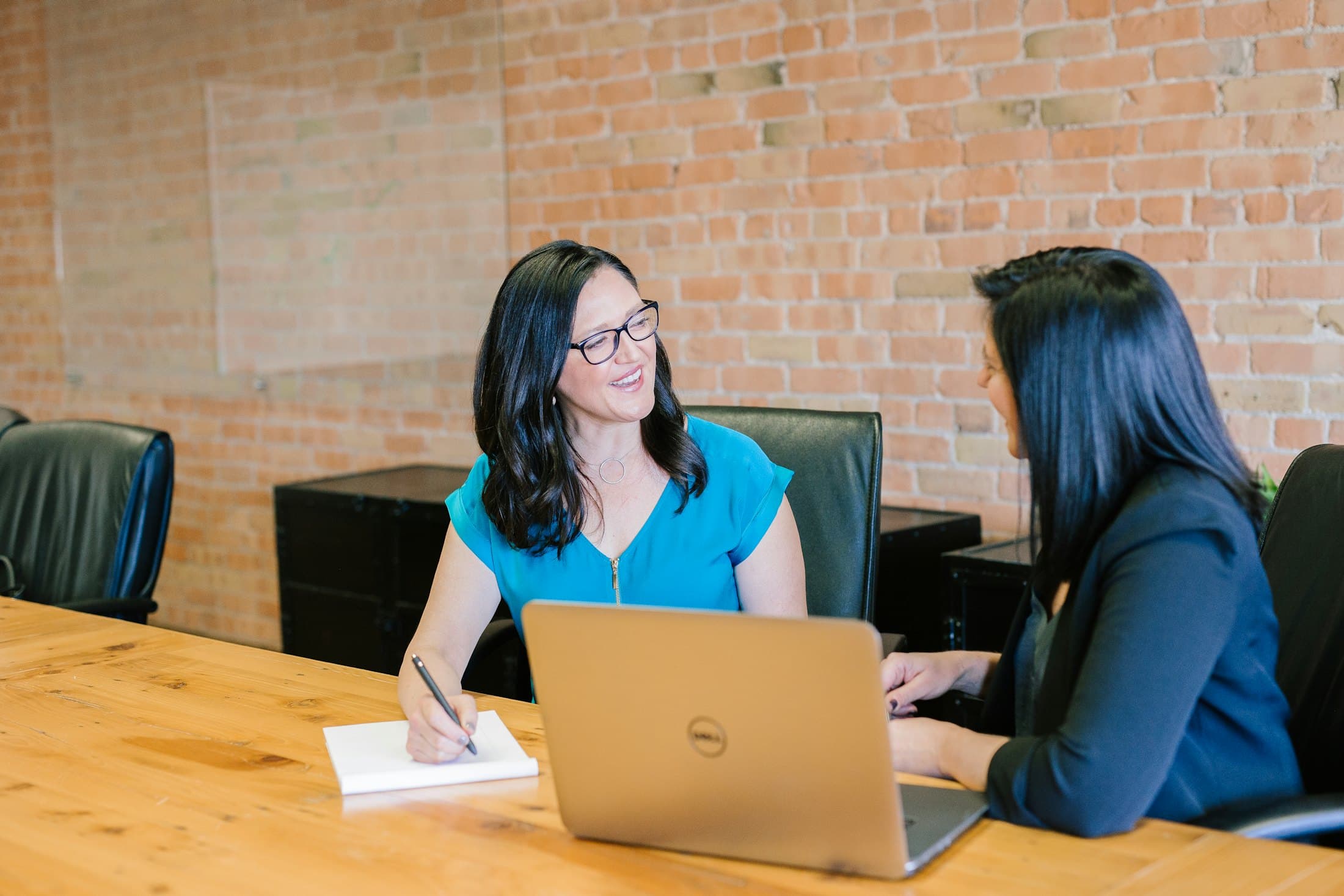 Two colleagues talking with a customer over a laptop